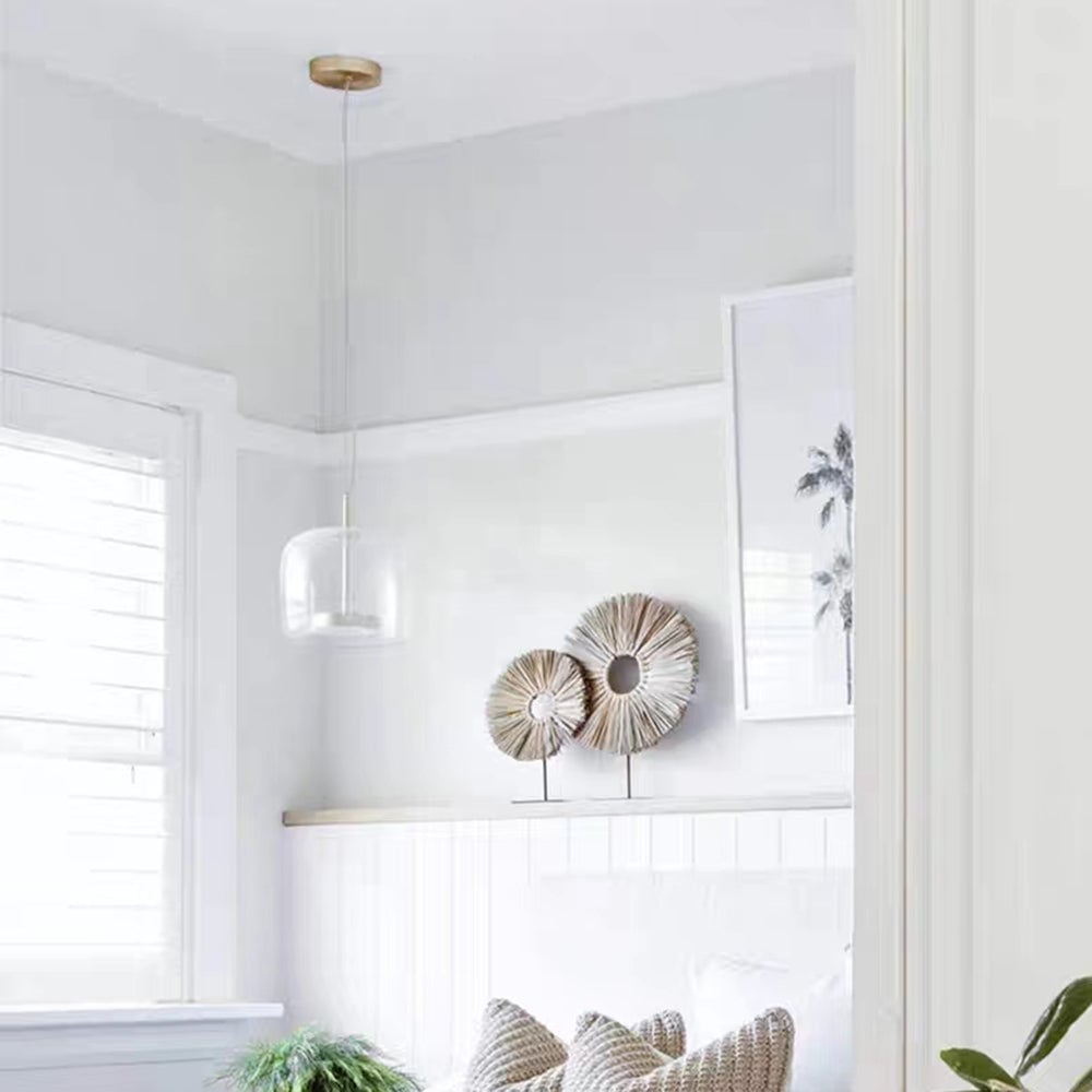 Clear Hailie pendant hanging beside a white fireplace