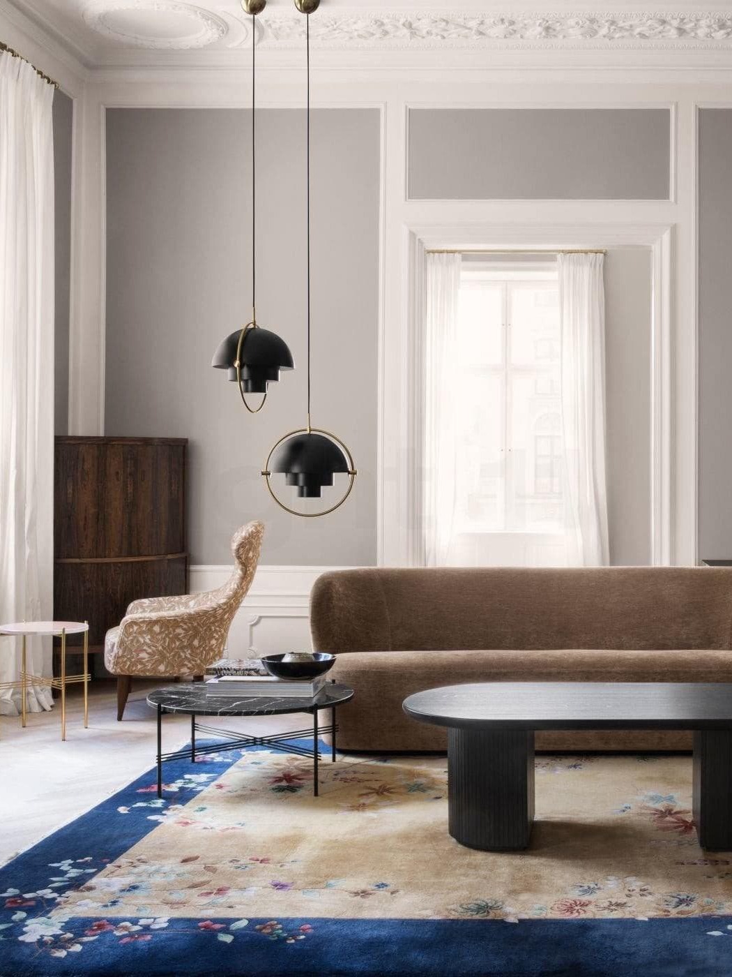 Pair of black metal pendants in a paneled living room