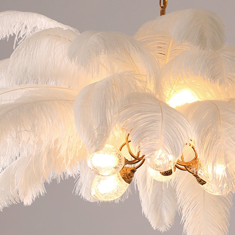 Close overlapping white feather layers and lit transparent globes on curved gold-toned O'Moore arms