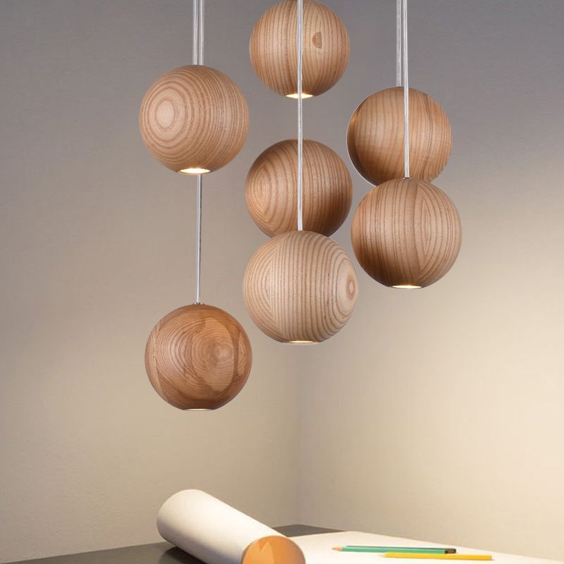 Seven spherical wooden pendants against a neutral wall