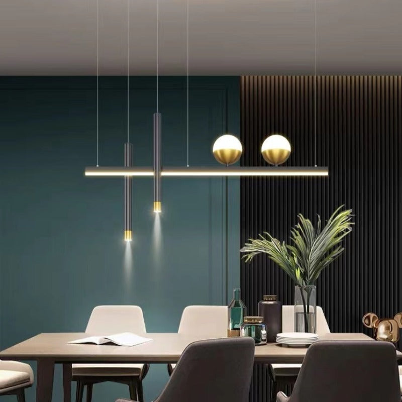 Madina black bar pendant above a dining table beside a plant.