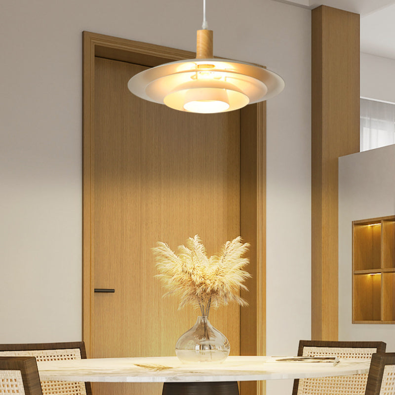 A layered white disc pendant above dining table