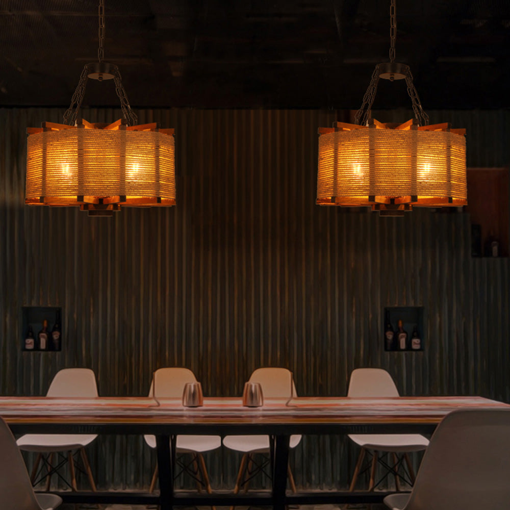 Two Austin drum pendants over a long wooden table with white chairs against a dark timber wall