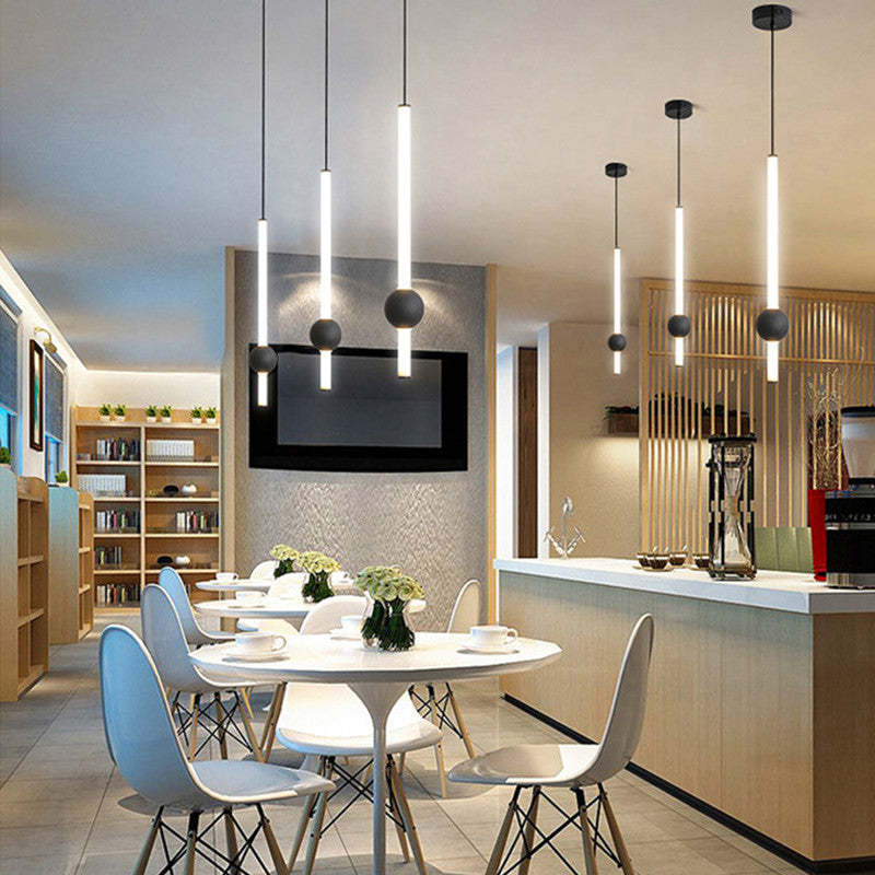 Several Carr rod-and-globe pendants arranged above a dining area.
