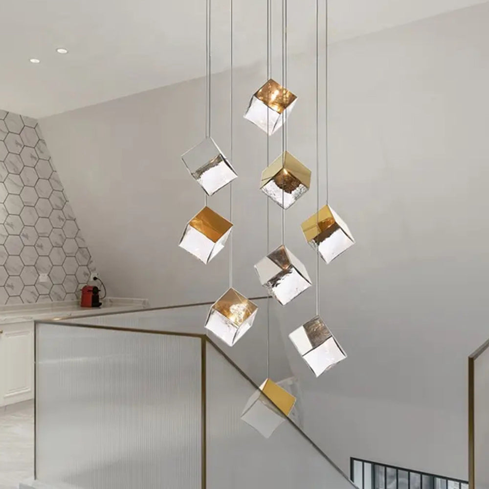 Gold-capped glass cube pendant group by white staircase