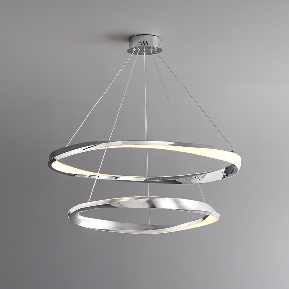 Silver double-ring pendant with reflective rims and pale illuminated bands against a gray background