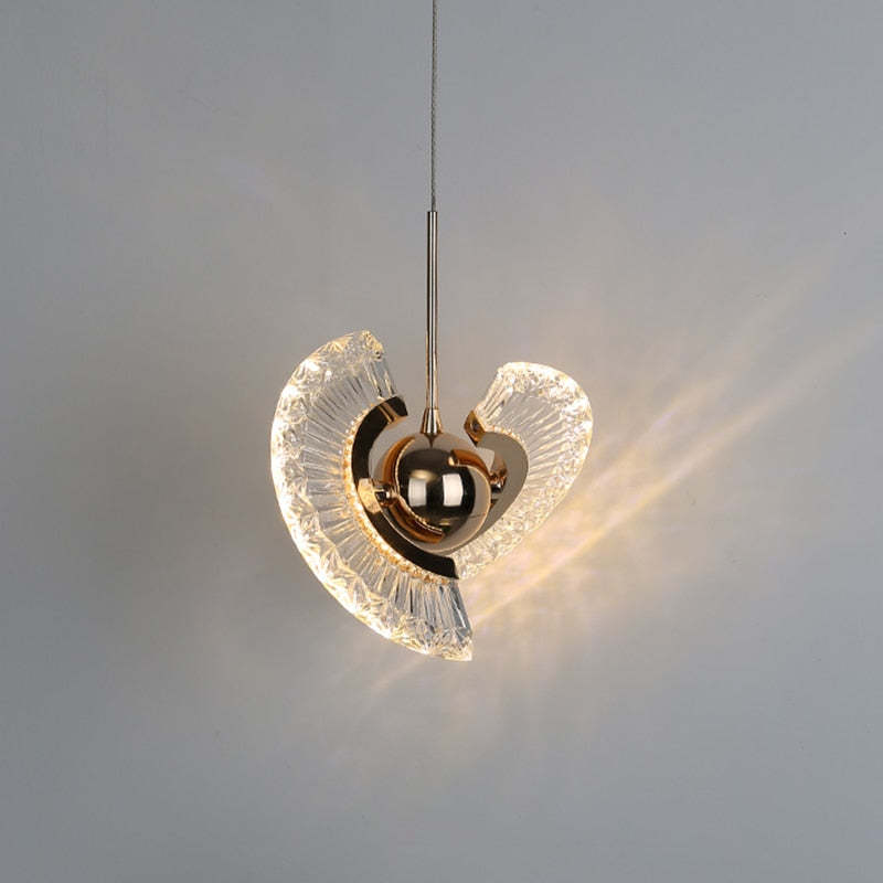 Gold Kristy against grey with angled overlapping fan-shaped acrylic halves and a light pattern to the right