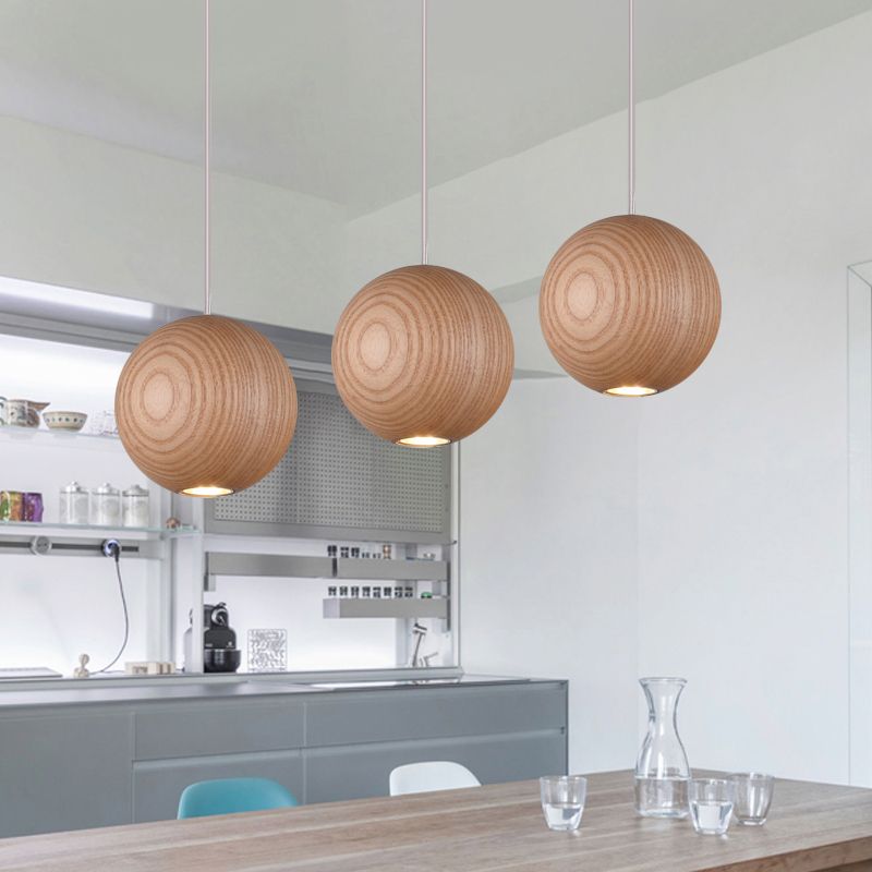 Three wooden globe pendants above dining table