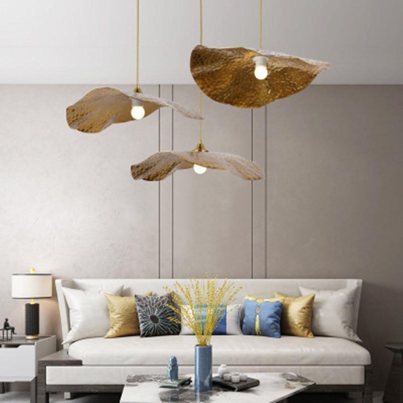 Gold lotus leaf pendants displayed above a living-room sofa