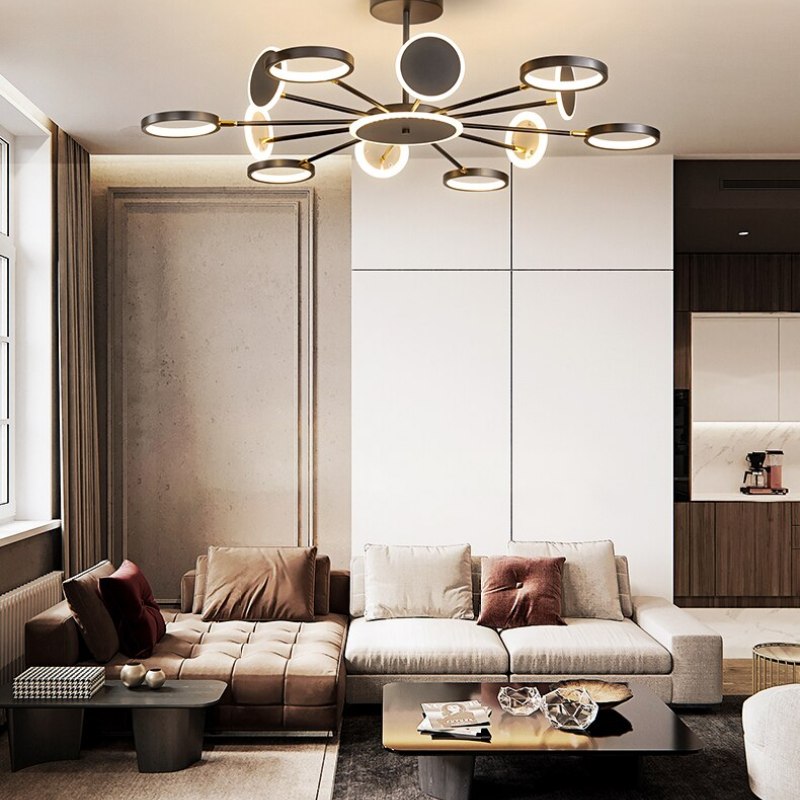 Twelve-arm ring and disc chandelier with mixed head angles above white and brown living-room sofas