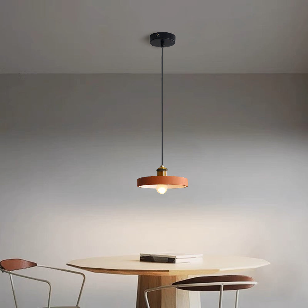 Orange Morandi disc pendant above a round dining table.