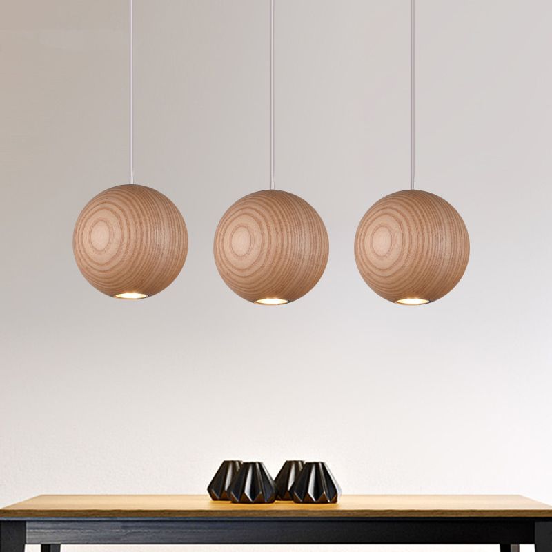 Three wood-grain globes pictured in a row above a table