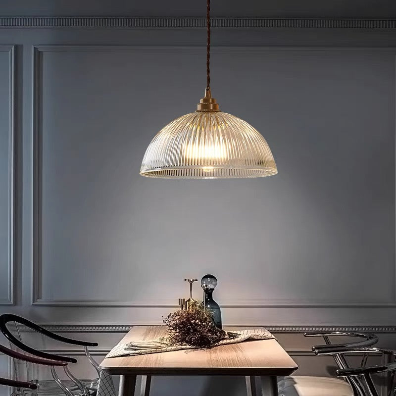 Alessio glass pendant above a wooden dining table in a paneled room