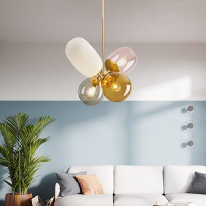 Morandi pink, white, amber and smoky glass shades above a sofa.
