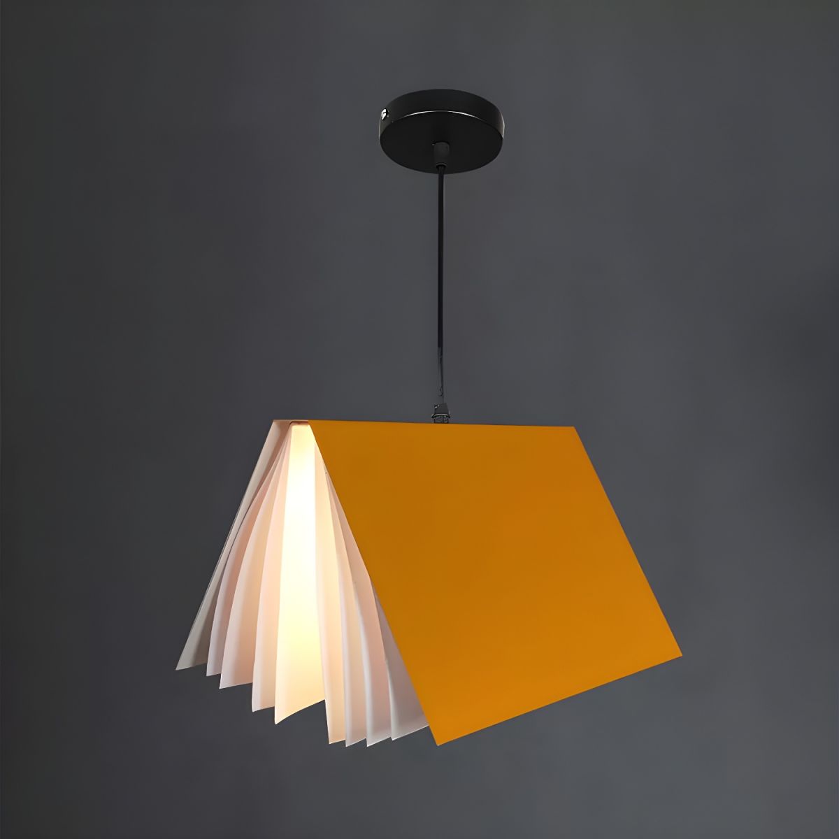 Yellow book pendant illuminated against dark backdrop