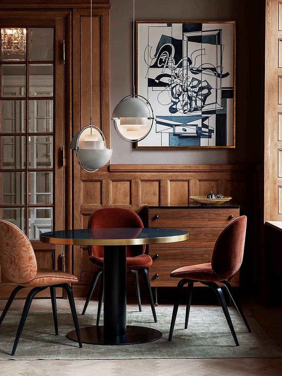 Two white rotating-shade pendants above a dining table