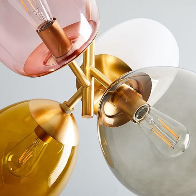 Close view of Morandi glass shades, exposed bulbs and gold-tone metal connections.