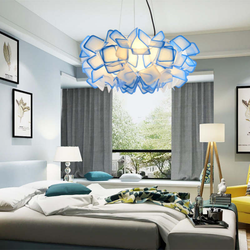 Blue Bella flower pendant above a bed with pillows, framed botanical prints, bedside lamps and a large window
