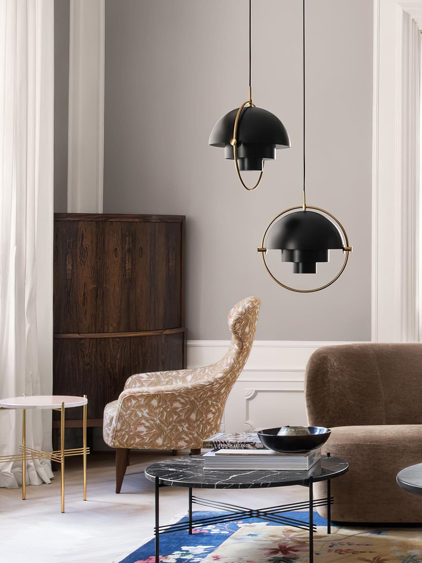 Two black rotating-shade pendants above living-room seating