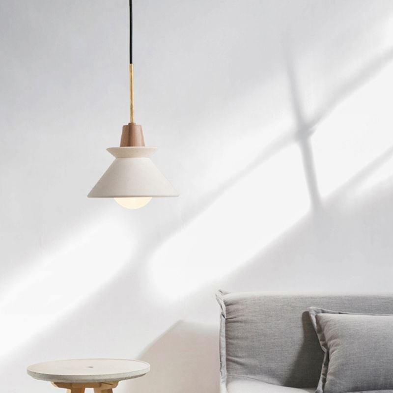White Ozawa pendant illuminated beside a small round table.