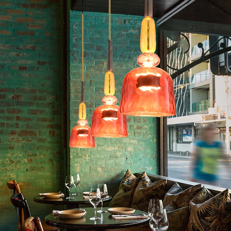 Three rosy red glass pendants above dining table