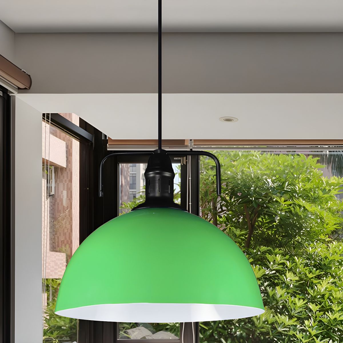 Green metal dome pendant beside window