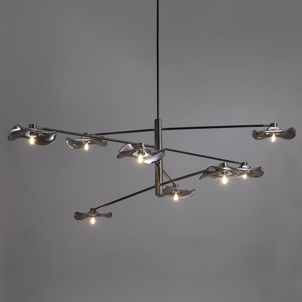 Eight-leaf Carins pendant with reflective wavy glass shades, black branches and lit bulbs against gray