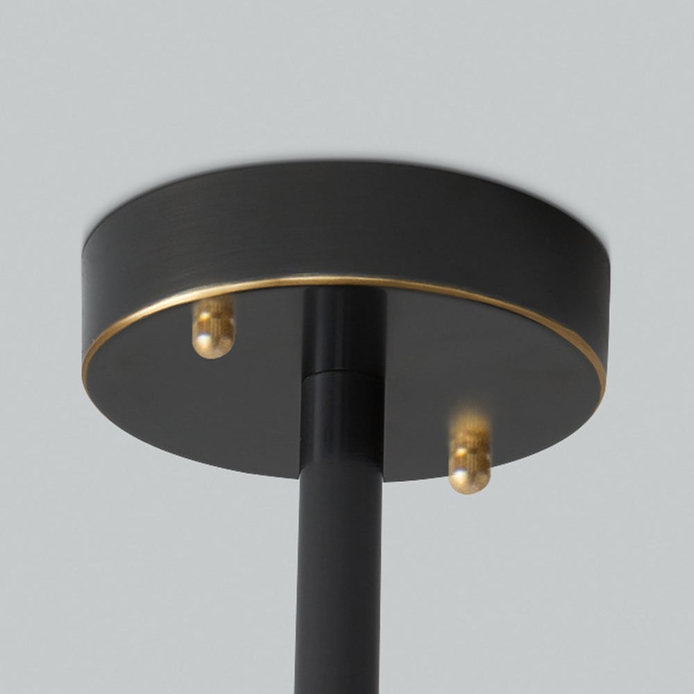 Close-up of a black round canopy and straight stem with two gold-tone fasteners
