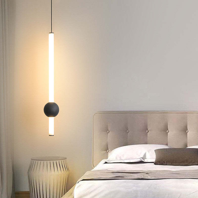 Carr Style A with illuminated white rod and black globe beside a bed.