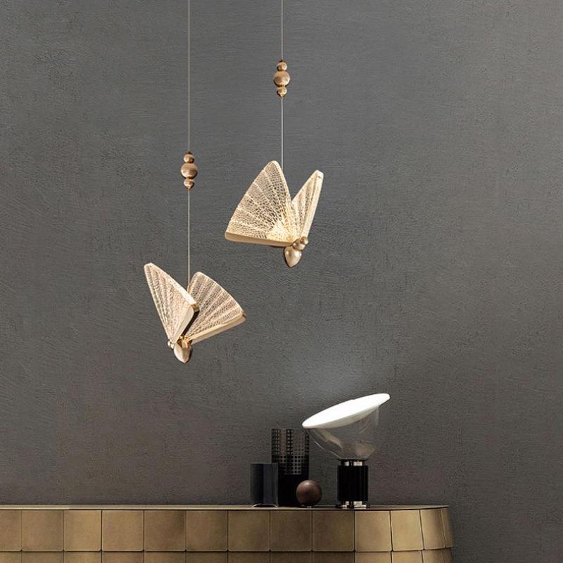 Two illuminated Kady butterfly pendants above a sideboard