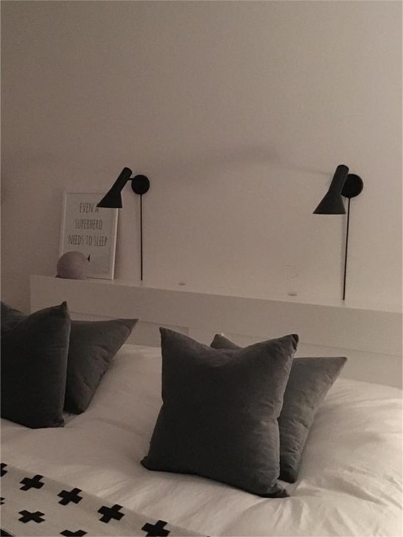 Two black Calix lamps mounted above a bed