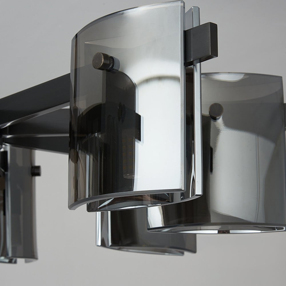 Close-up of unlit curved glass panels, rounded fasteners and black metal arms with reflections