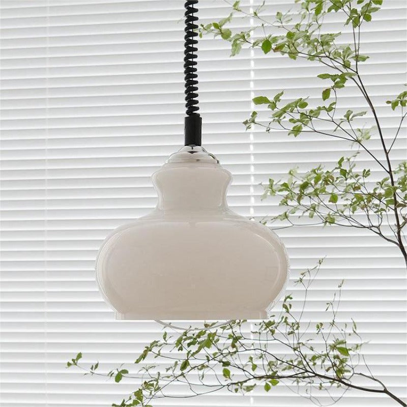 White glass dome pendant near window and foliage