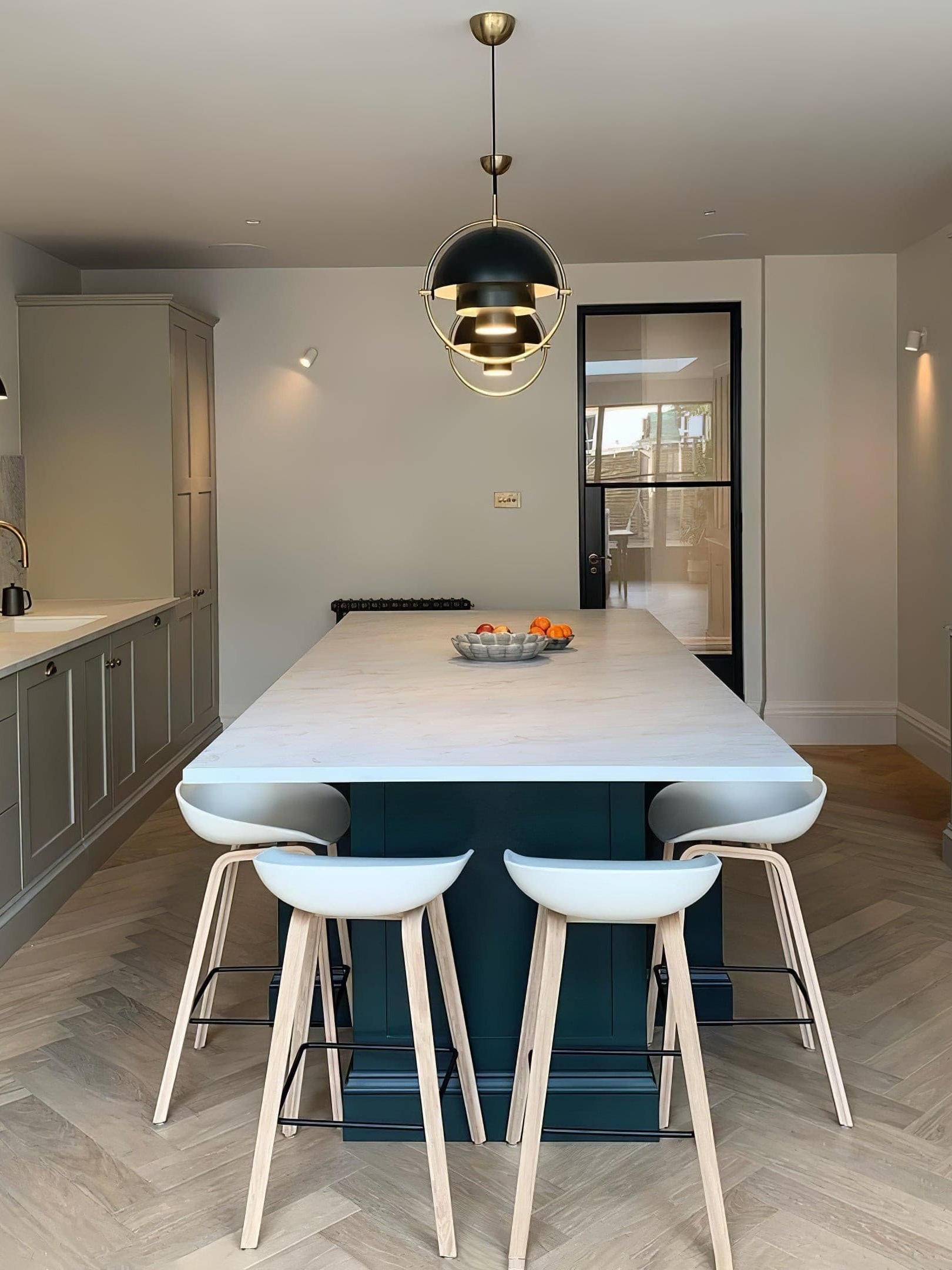 Dark dome pendant above a pale kitchen island