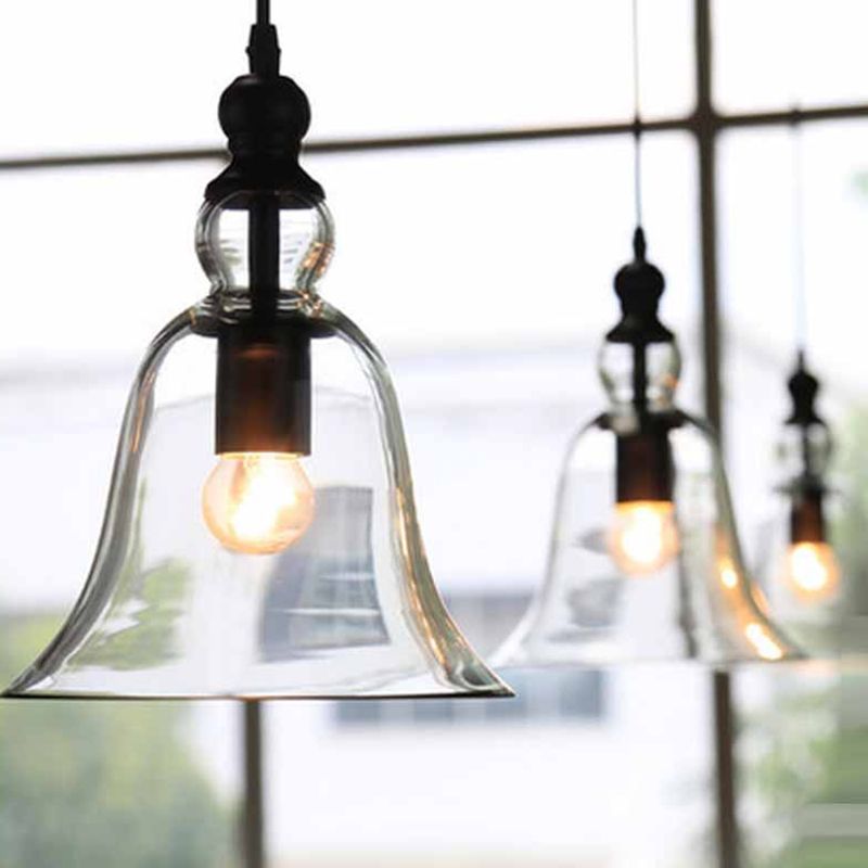 Close view of an illuminated Cooley bell pendant in front of a window.