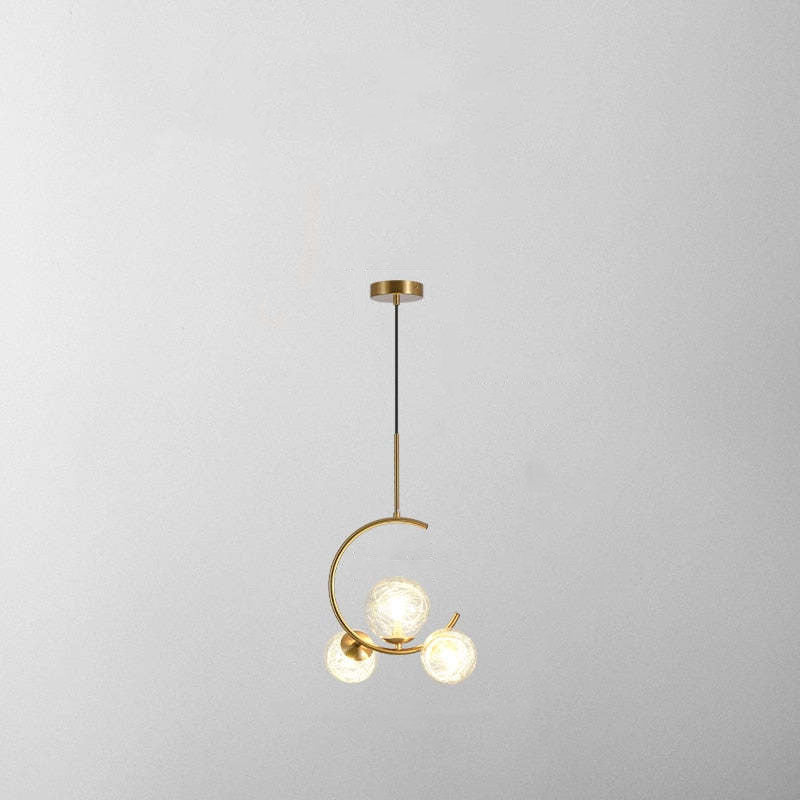 Isolated three-clear-globe crescent pendant with black cord, gold-tone stem and round canopy