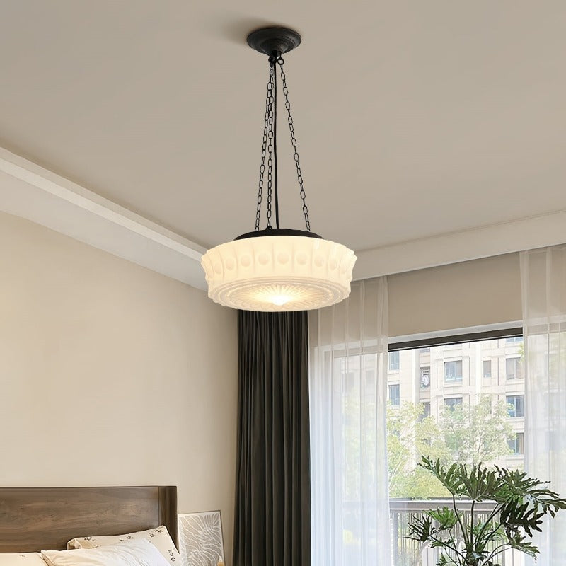 Pale embossed glass pendant glowing in bedroom