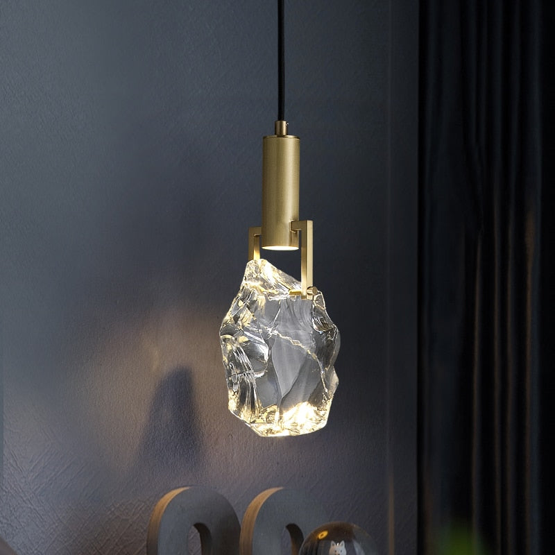 Illuminated Kristy crystal drop casting light beside a dark wall.
