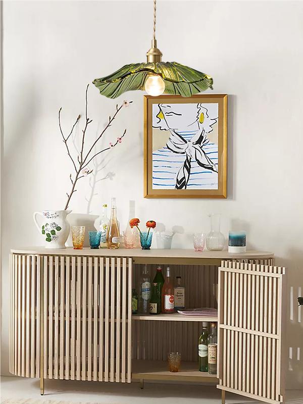 Wide green lotus glass pendant above a wooden sideboard