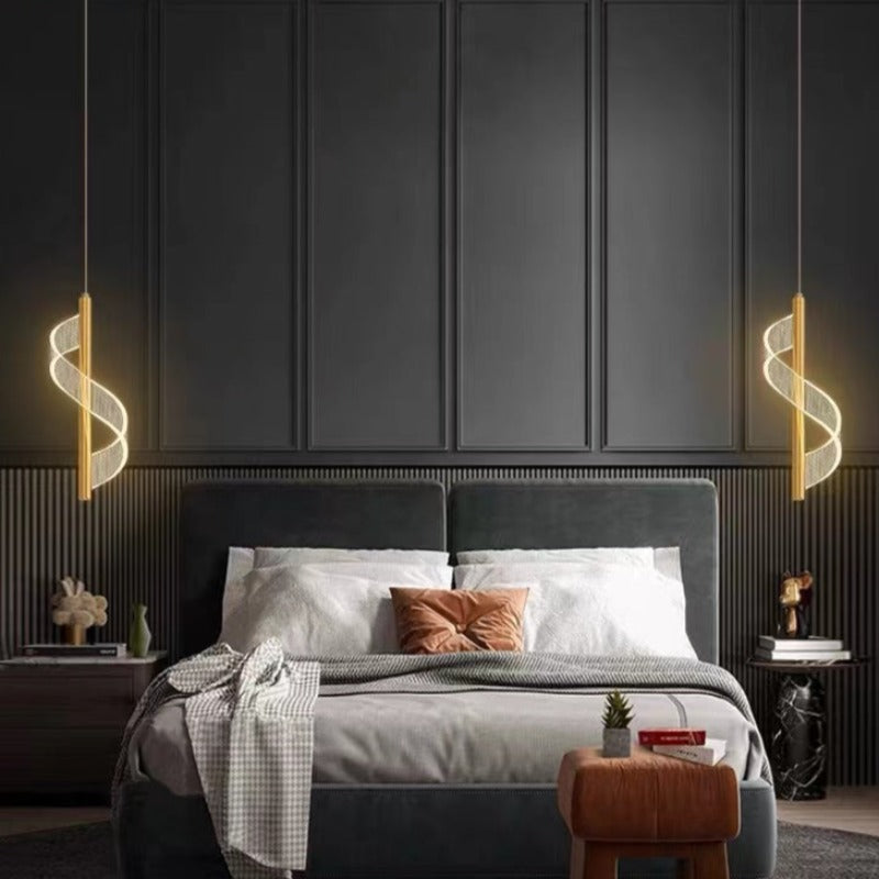 Sanna gold spiral ribbon pendants beside a bed against dark wall panels.