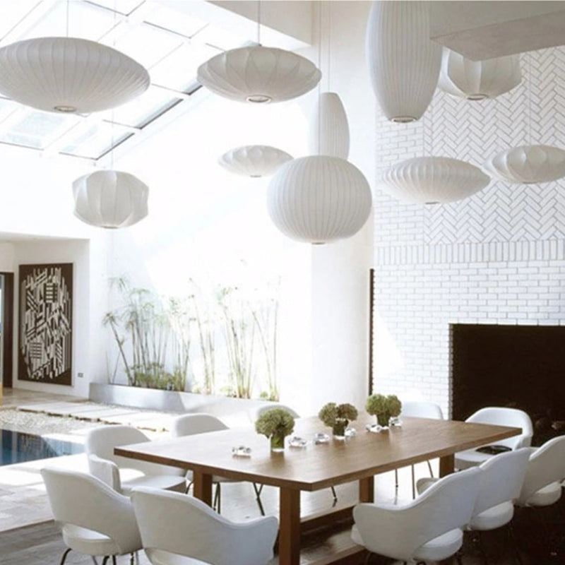 White pleated pendant collection above long dining table