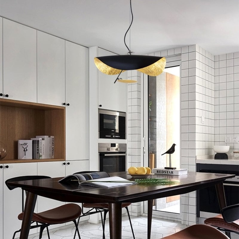 Renée black-and-gold pendant above a dining table near a kitchen