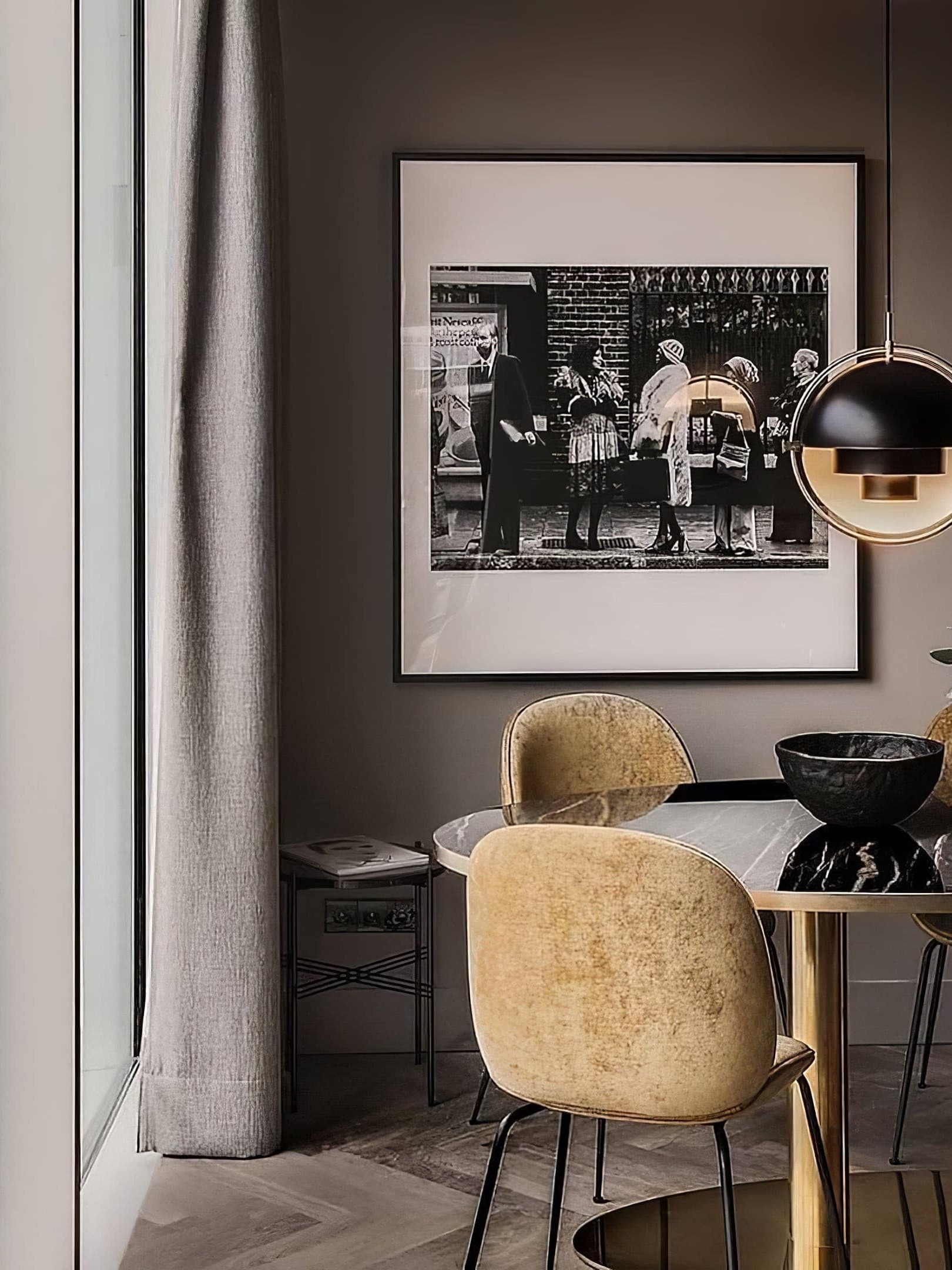Black and copper-coloured pendant above a dining setting