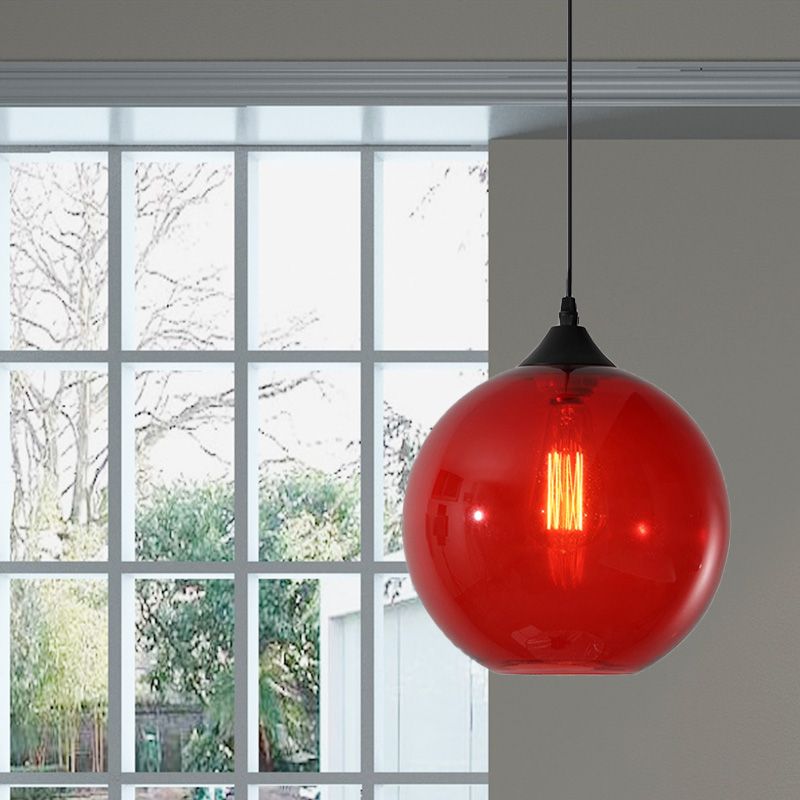Red glass globe pendant beside a window