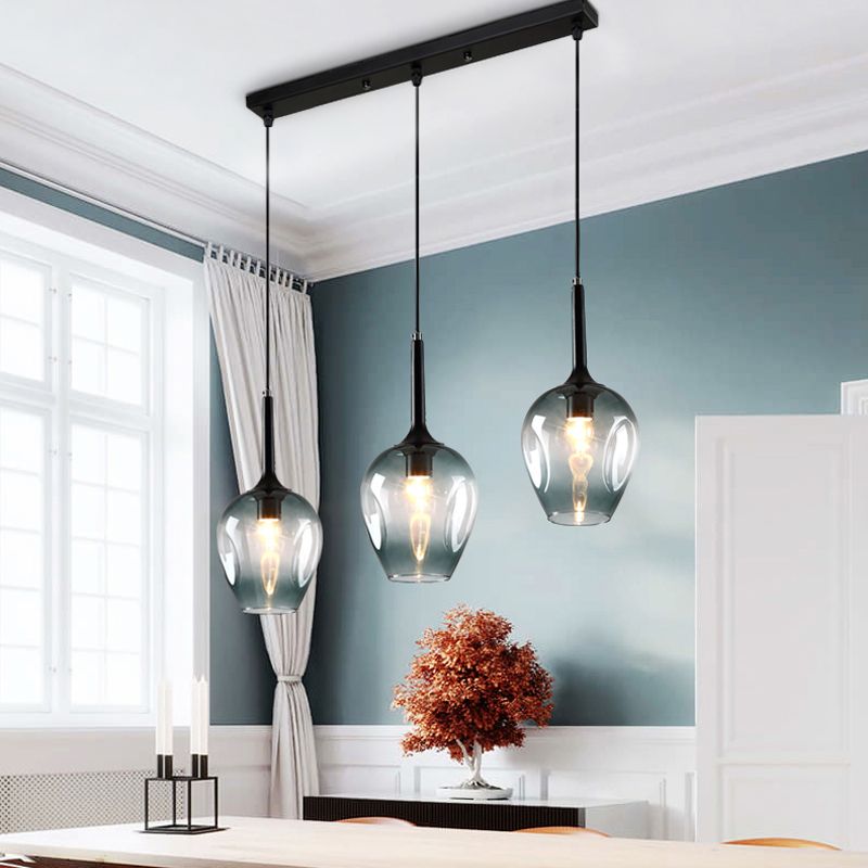 Hailie three-shade glass pendant pictured at staggered heights above a kitchen island
