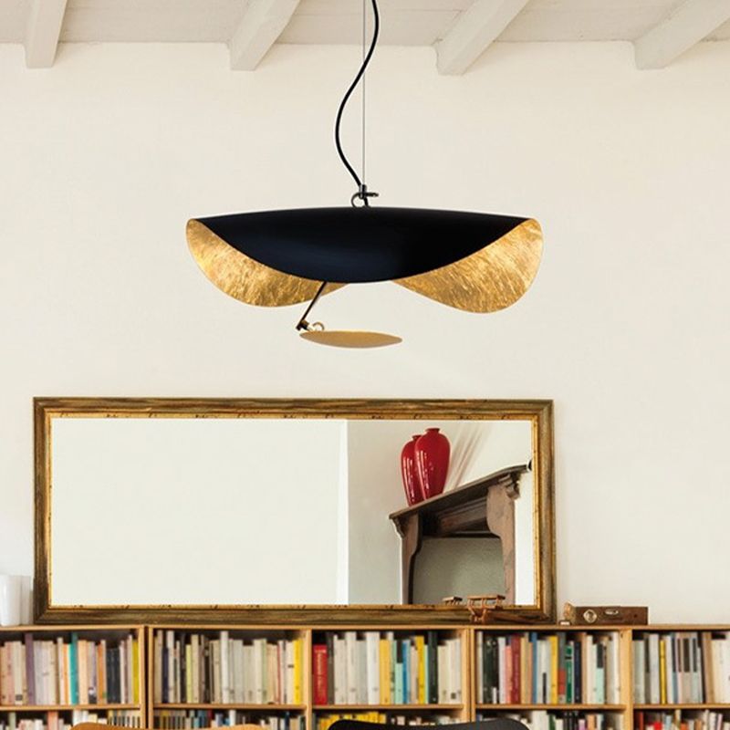 Black-and-gold Renée saucer pendant above a bookcase