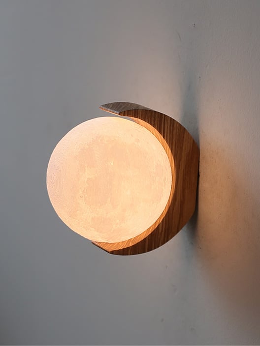 Opposite close-up of glowing moon texture and curved wood bracket with upper and lower tips