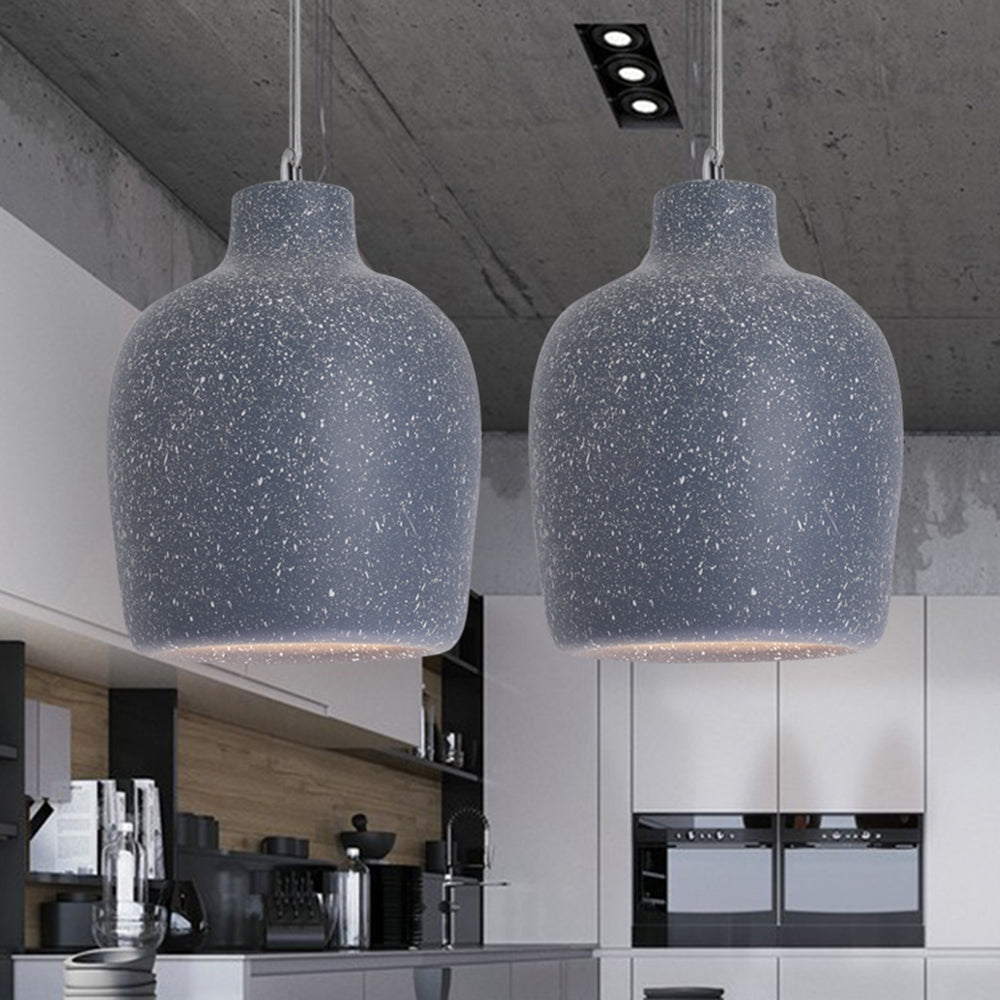 Two speckled Dark Blue Byers jar-shaped pendant lights above a kitchen counter, with wood backsplash, white cabinets and built-in ovens behind.