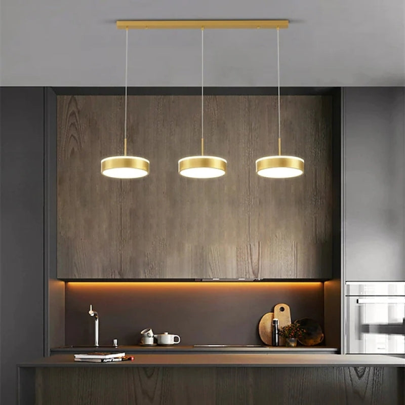 Gold Raheel three-disc pendant above a kitchen counter.