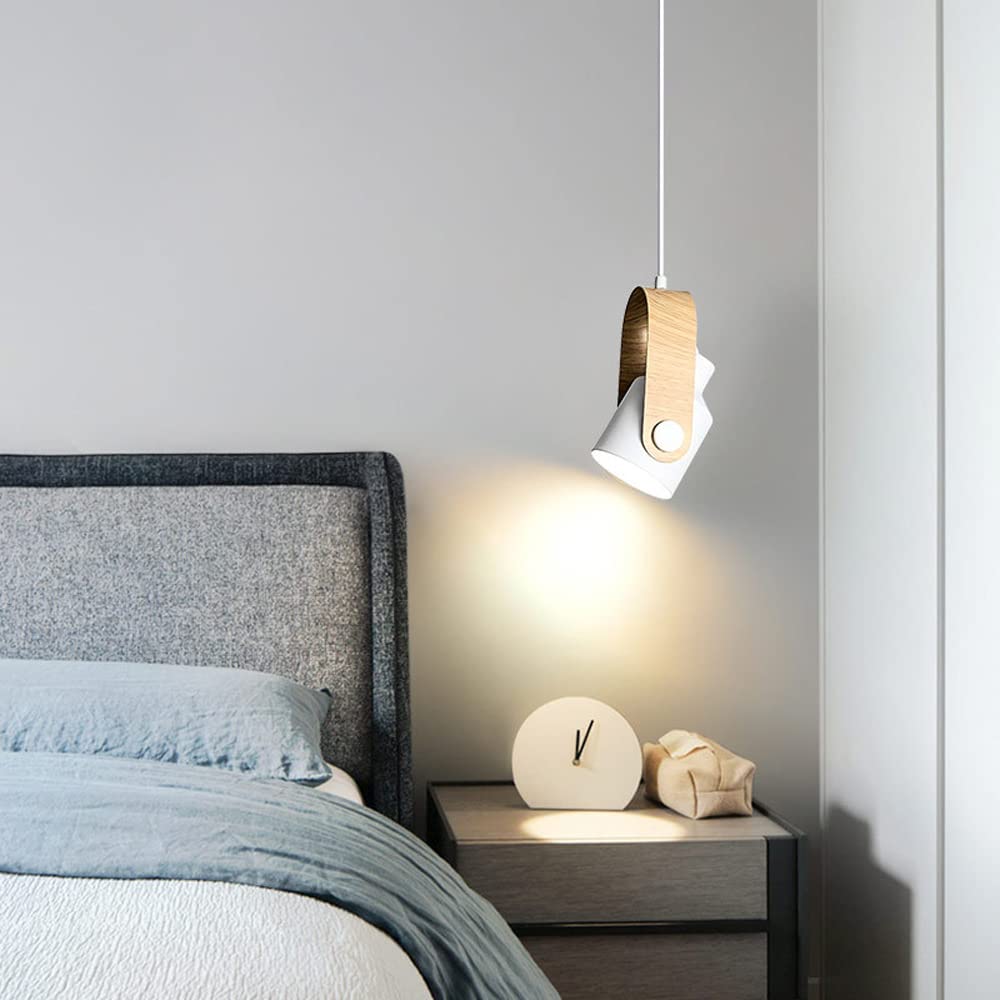 White pivoting spotlight pendant aimed at bedside table
